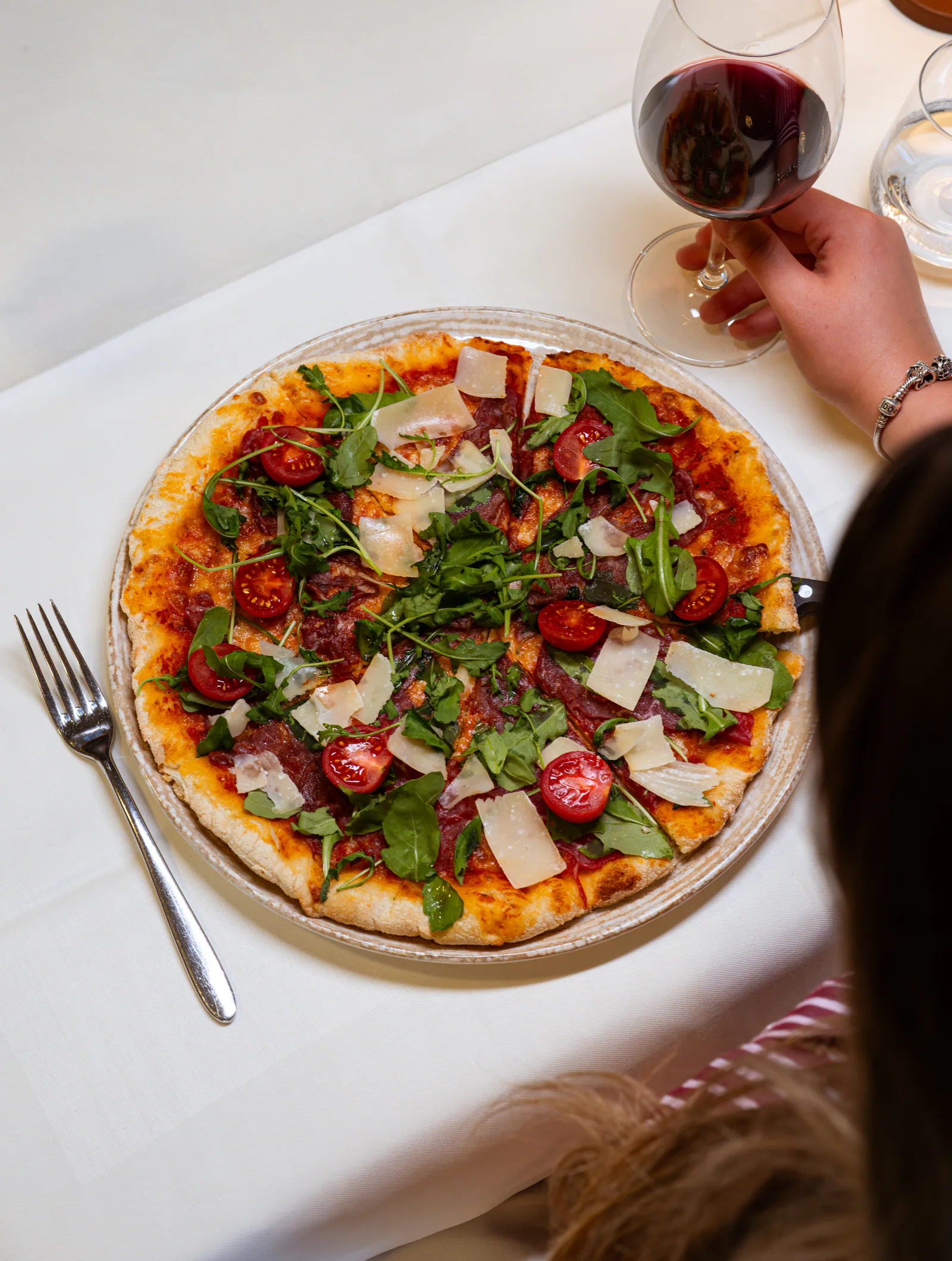 Frisch servierte Pizza mit Rucola und Parmesan im Wies