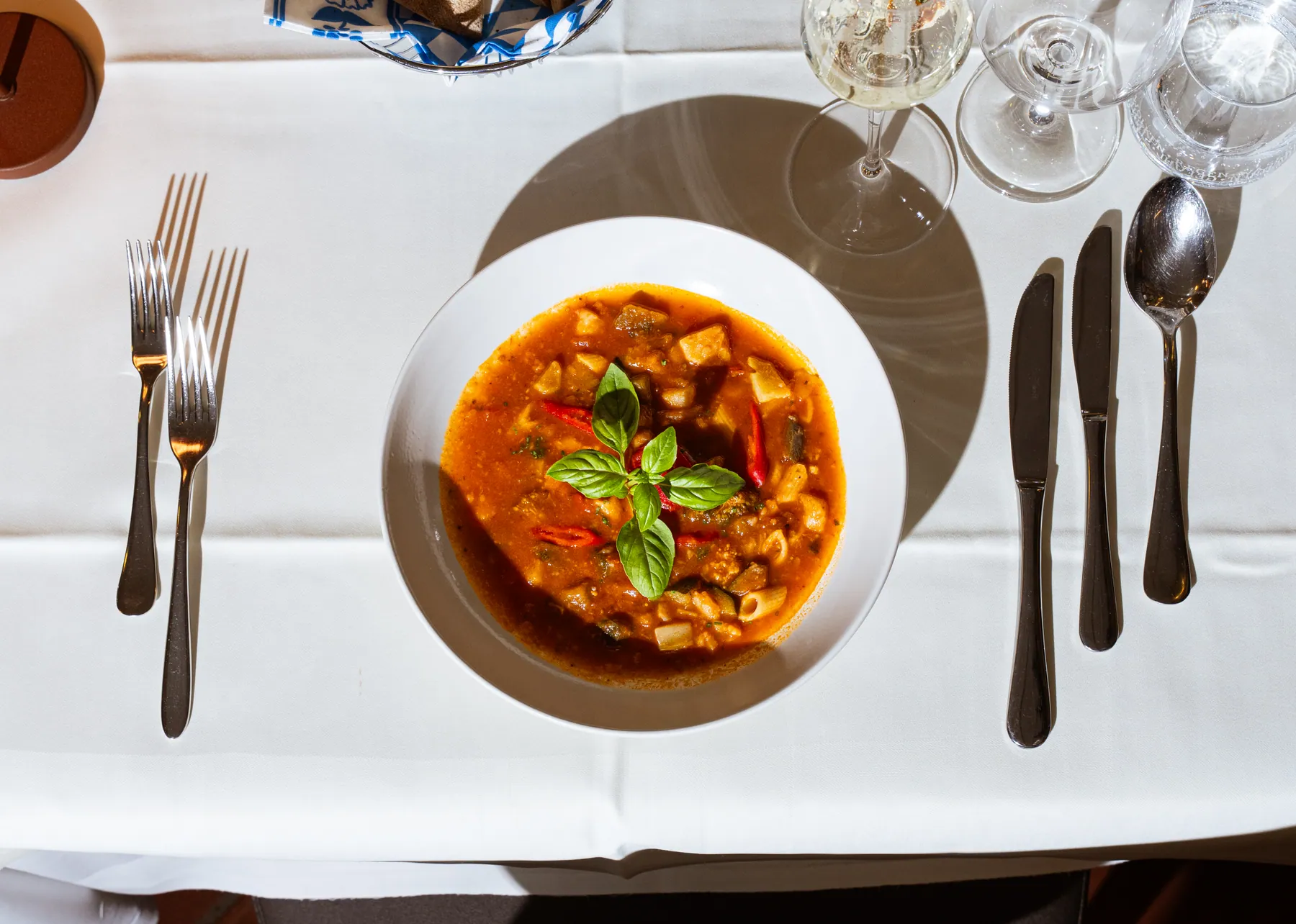 Minestrone mit frischem Basilikum auf einem gedeckten Tisch