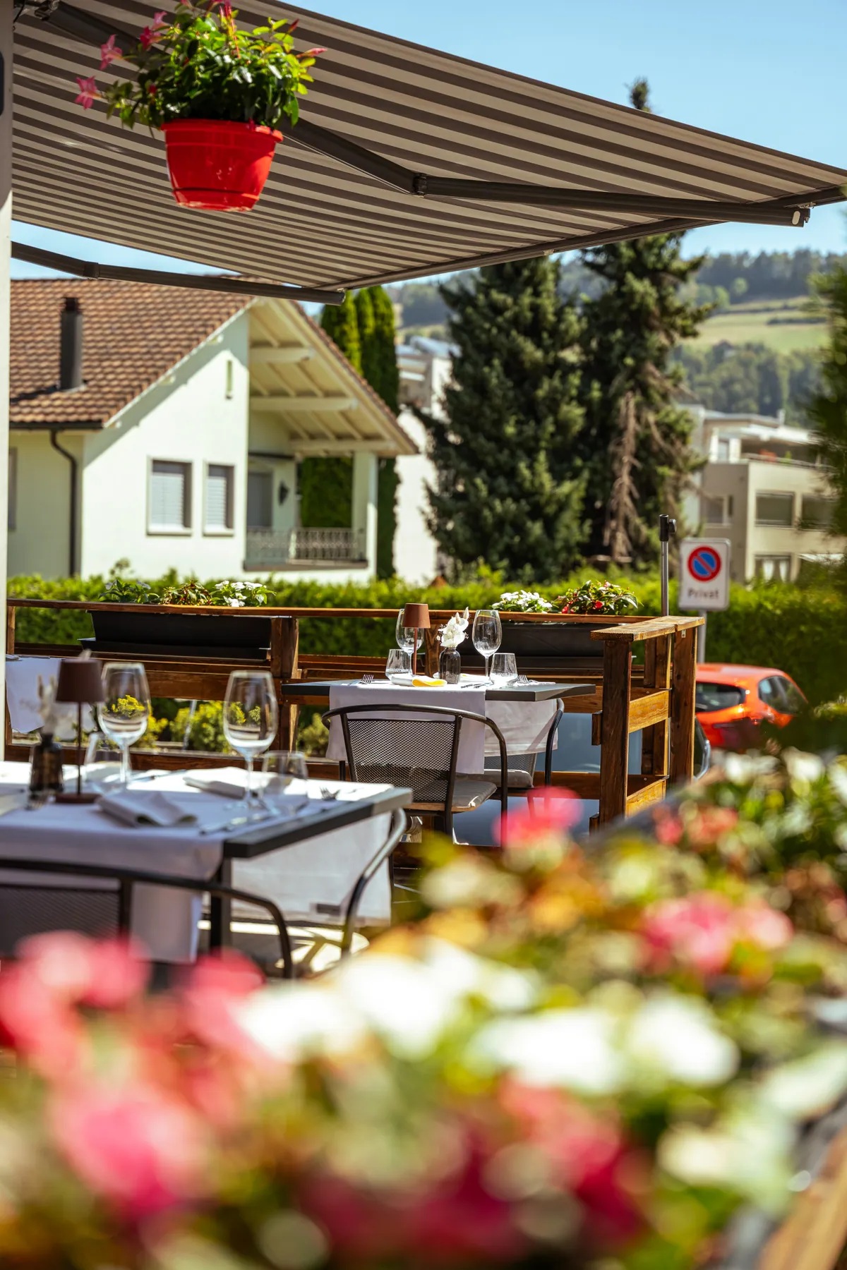 Blühende Terrasse mit gedeckten Tischen und Blick ins Toggenburg